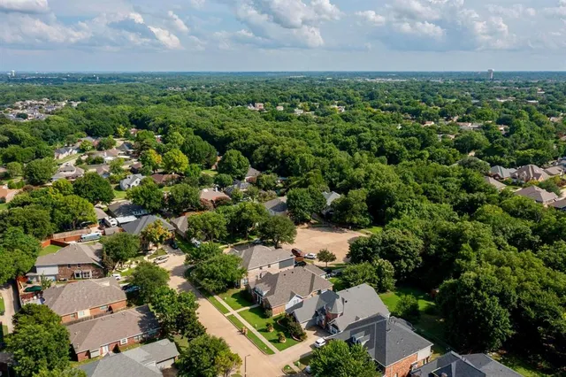 an aerial view of residential house with outdoor space and trees all around