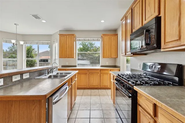 a kitchen with stainless steel appliances granite countertop a sink stove and cabinets