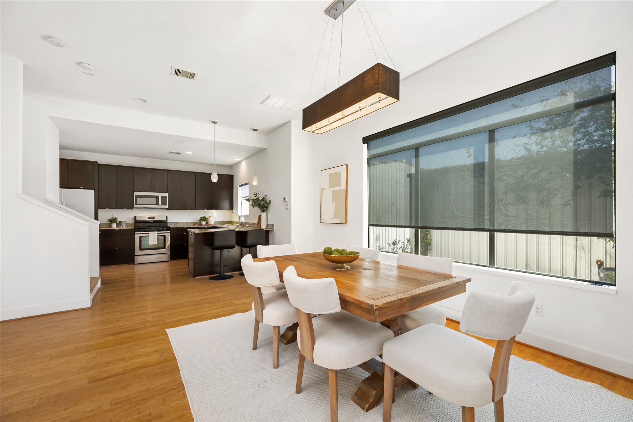 5012 Cornish Street Houston, TX 77007 - Photo 16 of 38 a dining room with wooden floor a glass table and chairs