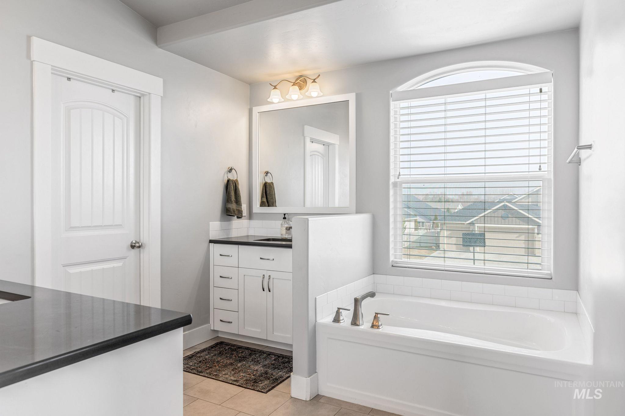 1127 Overland Trail Street Middleton, ID 83644 - Photo 15 of 24 Full bath with dual vanity, a garden tub, large mirrors, light tile floors, large walk-in shower and walk-in closet