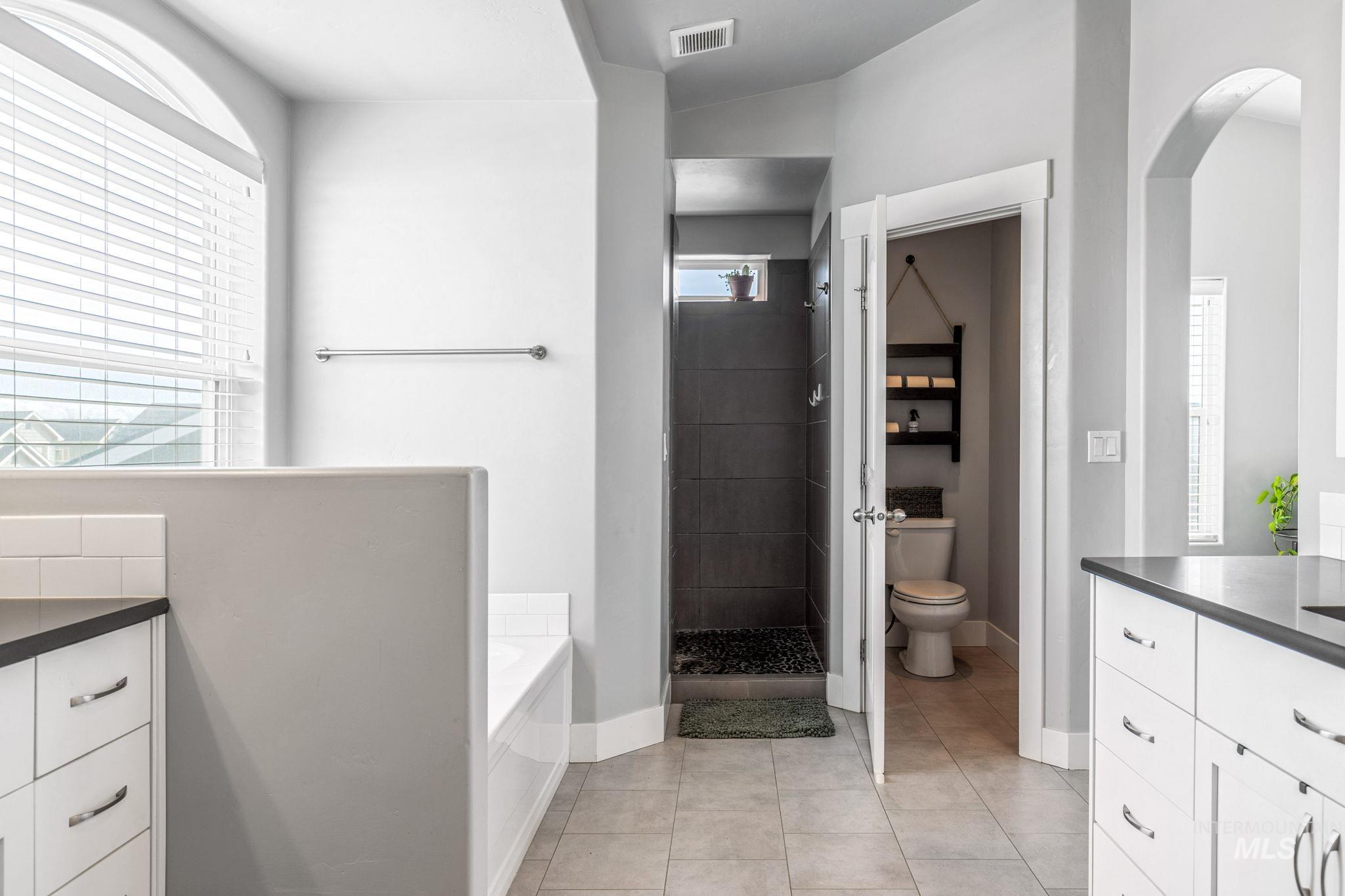 1127 Overland Trail Street Middleton, ID 83644 - Photo 16 of 24 Full bath with dual vanity, a garden tub, large mirrors, light tile floors, large walk-in shower and walk-in closet