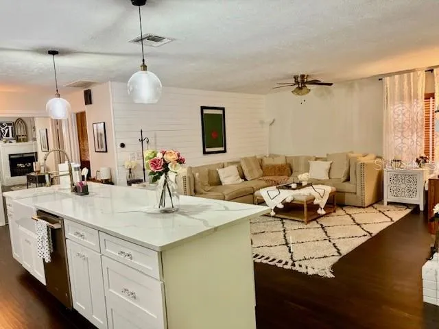 a living room with kitchen island furniture and a chandelier