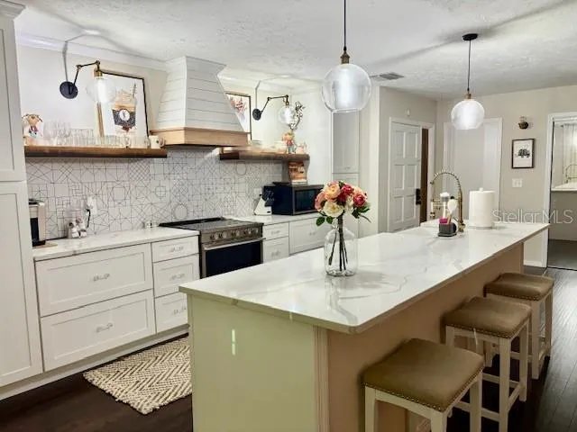 a kitchen with a sink a stove and chairs
