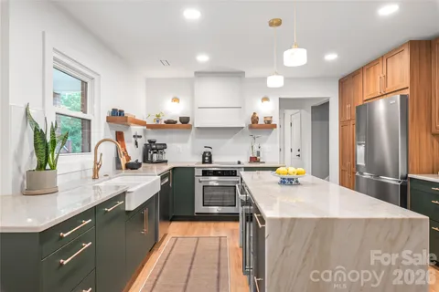 a kitchen with a sink a stove a refrigerator and black cabinets