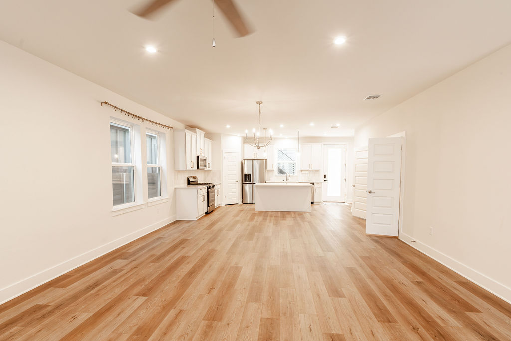 Gleaming hardwood floors and recessed lighting enhance this airy, open-concept living space.