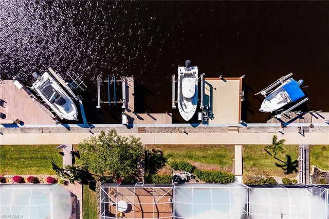 an aerial view of ocean and residential houses with outdoor space