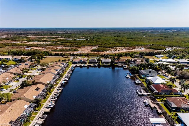 an aerial view of ocean and residential houses with outdoor space