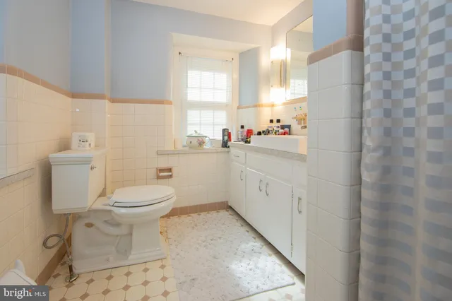 a bathroom with a toilet sink a vanity and mirror