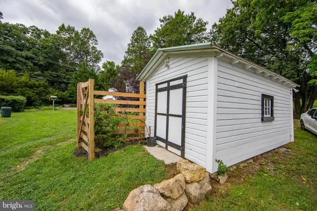 a view of backyard with wooden fence and large trees