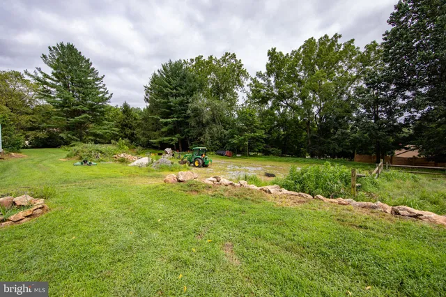 a view of a green field with wooden fence