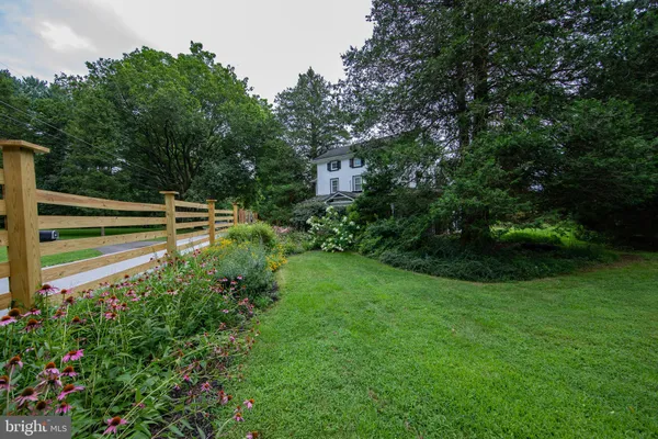 a view of a house with a backyard and a street