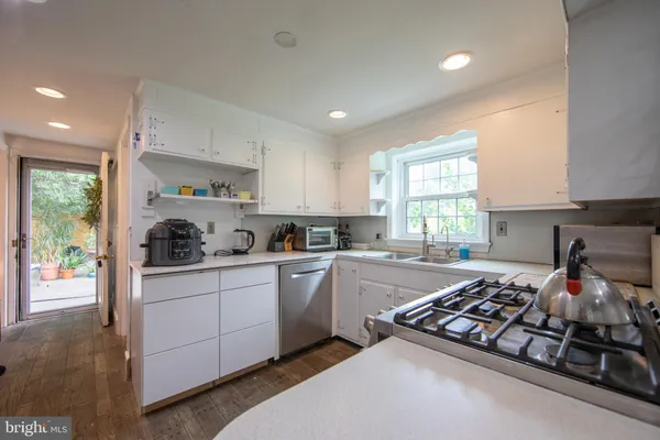 a kitchen with a stove a sink and a window