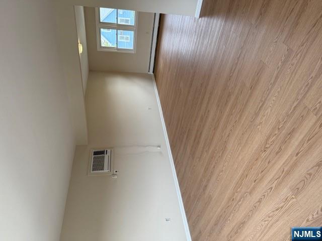 911 York Street, Unit 2 East Rutherford, NJ 07073 - Photo 3 of 12 a view of an empty room with wooden floor and windows