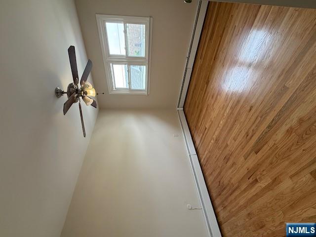 911 York Street, Unit 2 East Rutherford, NJ 07073 - Photo 8 of 12 an empty room with wooden floor fan and windows