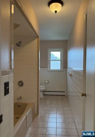 a bathroom with a tub shower and mirror