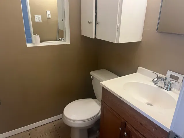 a bathroom with a sink a toilet and mirror