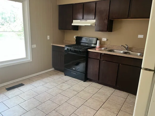 a kitchen with a sink cabinets and a window
