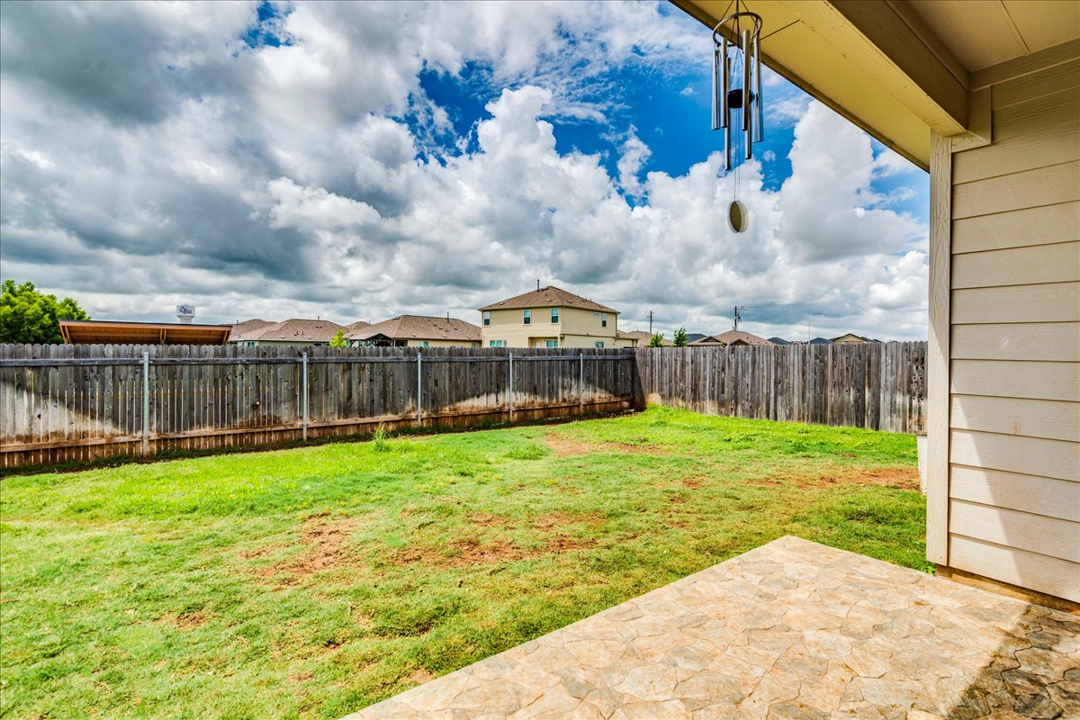 389 Salt Springs Road Kyle, TX 78640 - Photo 23 of 30 A fenced backyard offers a pleasant outdoor retreat with a paved patio.