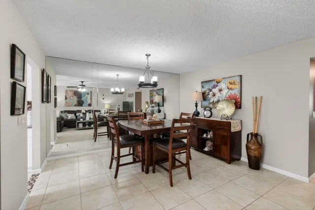 a view of a dining room with furniture and a chandelier fan