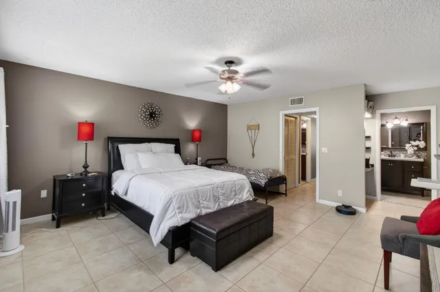 a spacious bedroom with a bed and a chandelier