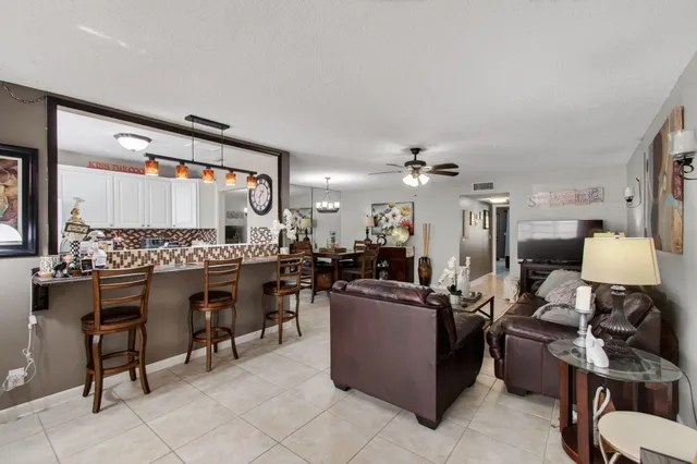 a living room with furniture a flat screen tv and kitchen view