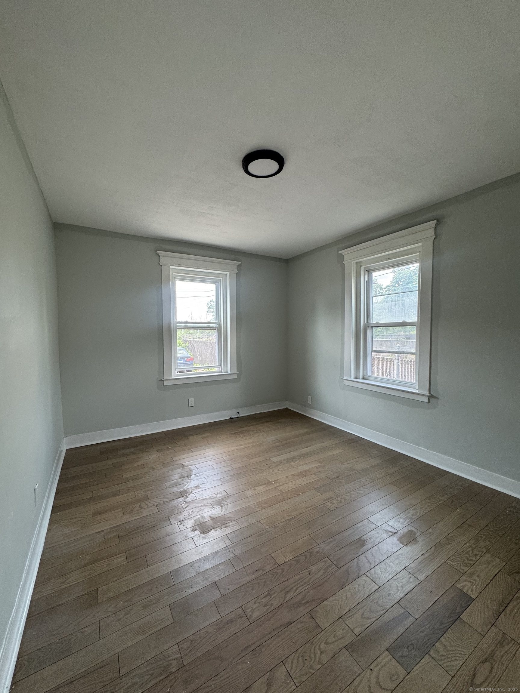 648 Ferry Street, Unit 3 New Haven, CT 06513 - Photo 6 of 9 an empty room with wooden floor and windows