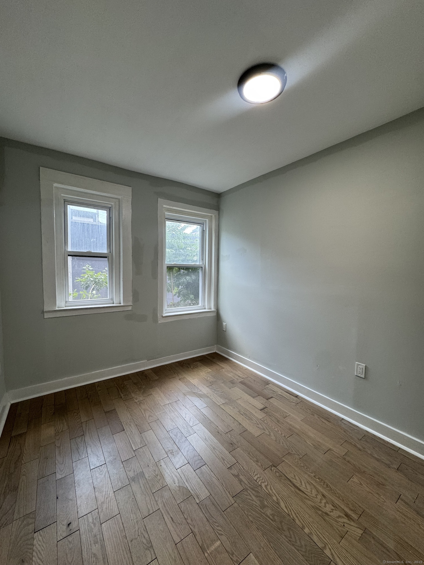 648 Ferry Street, Unit 3 New Haven, CT 06513 - Photo 7 of 9 an empty room with wooden floor and windows