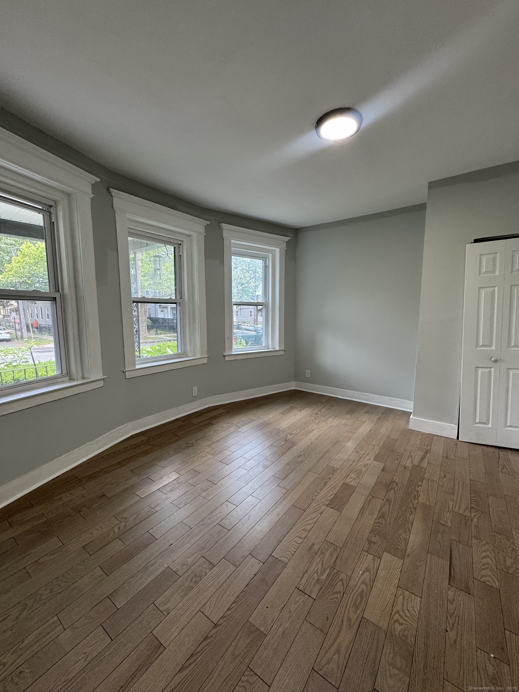 648 Ferry Street, Unit 3 New Haven, CT 06513 - Photo 8 of 9 an empty room with wooden floor and windows
