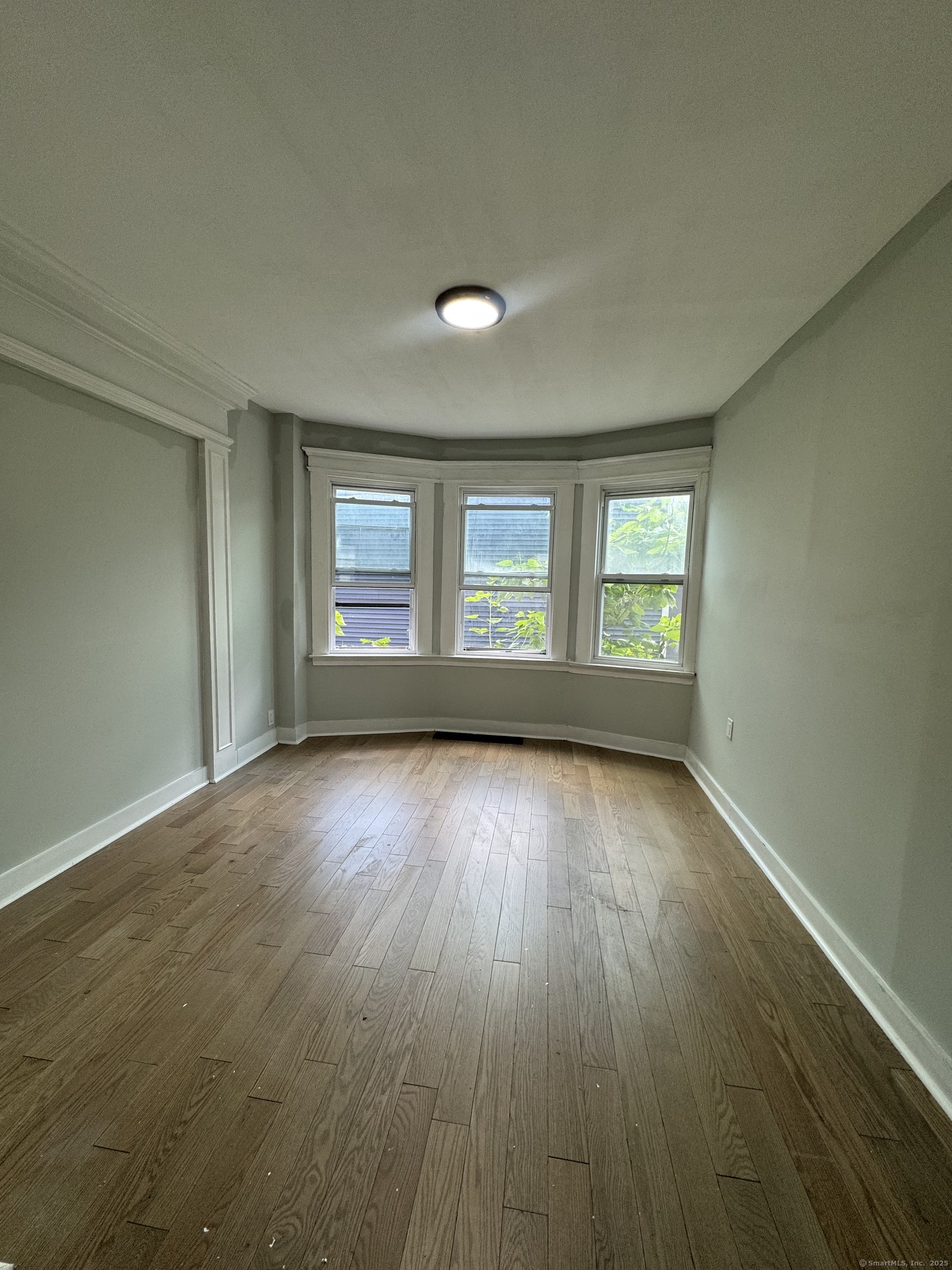 648 Ferry Street, Unit 3 New Haven, CT 06513 - Photo 9 of 9 an empty room with wooden floor and windows