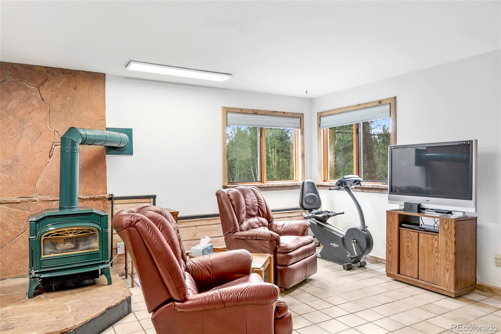 444 Nova Road Pine, CO 80470 - Photo 23 of 40 a living room with furniture a flat screen tv and floor to ceiling window