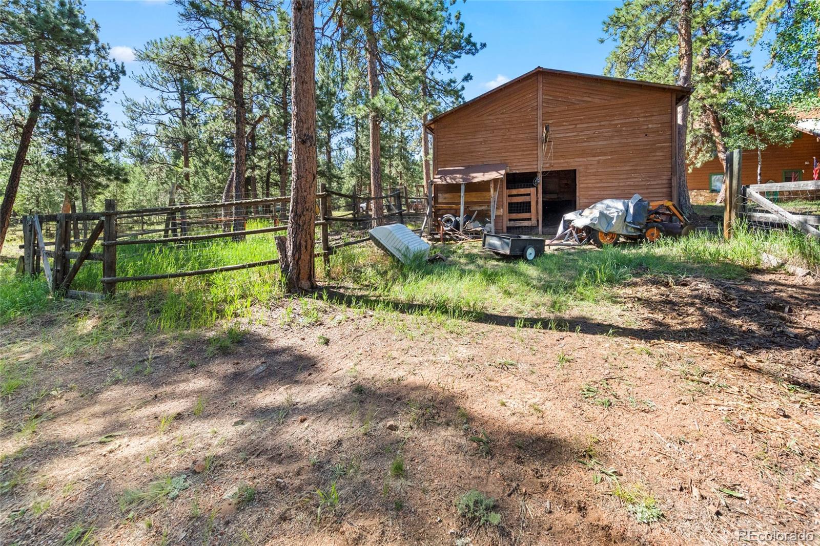 444 Nova Road Pine, CO 80470 - Photo 34 of 40 a view of a house that has a small yard and a large tree