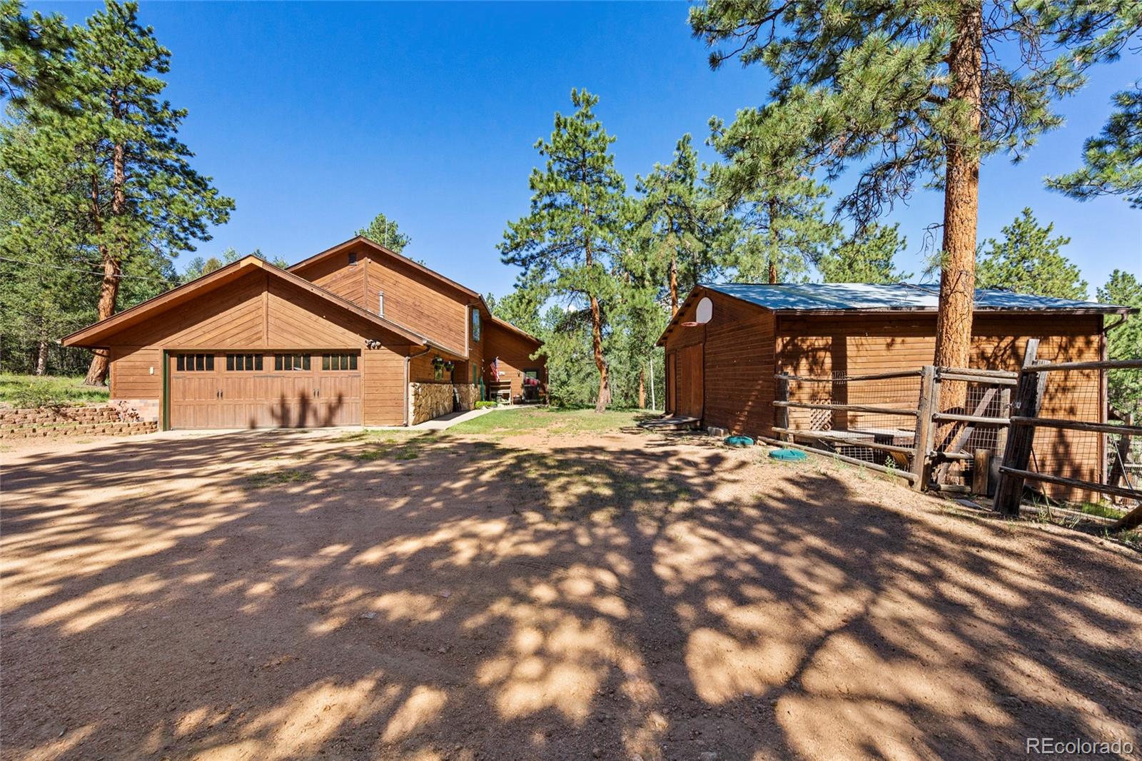 444 Nova Road Pine, CO 80470 - Photo 37 of 40 a view of a house with wooden walls and a tree