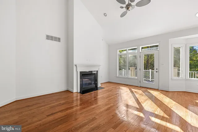 a kitchen with stainless steel appliances granite countertop a refrigerator a stove and a sink with wooden floor