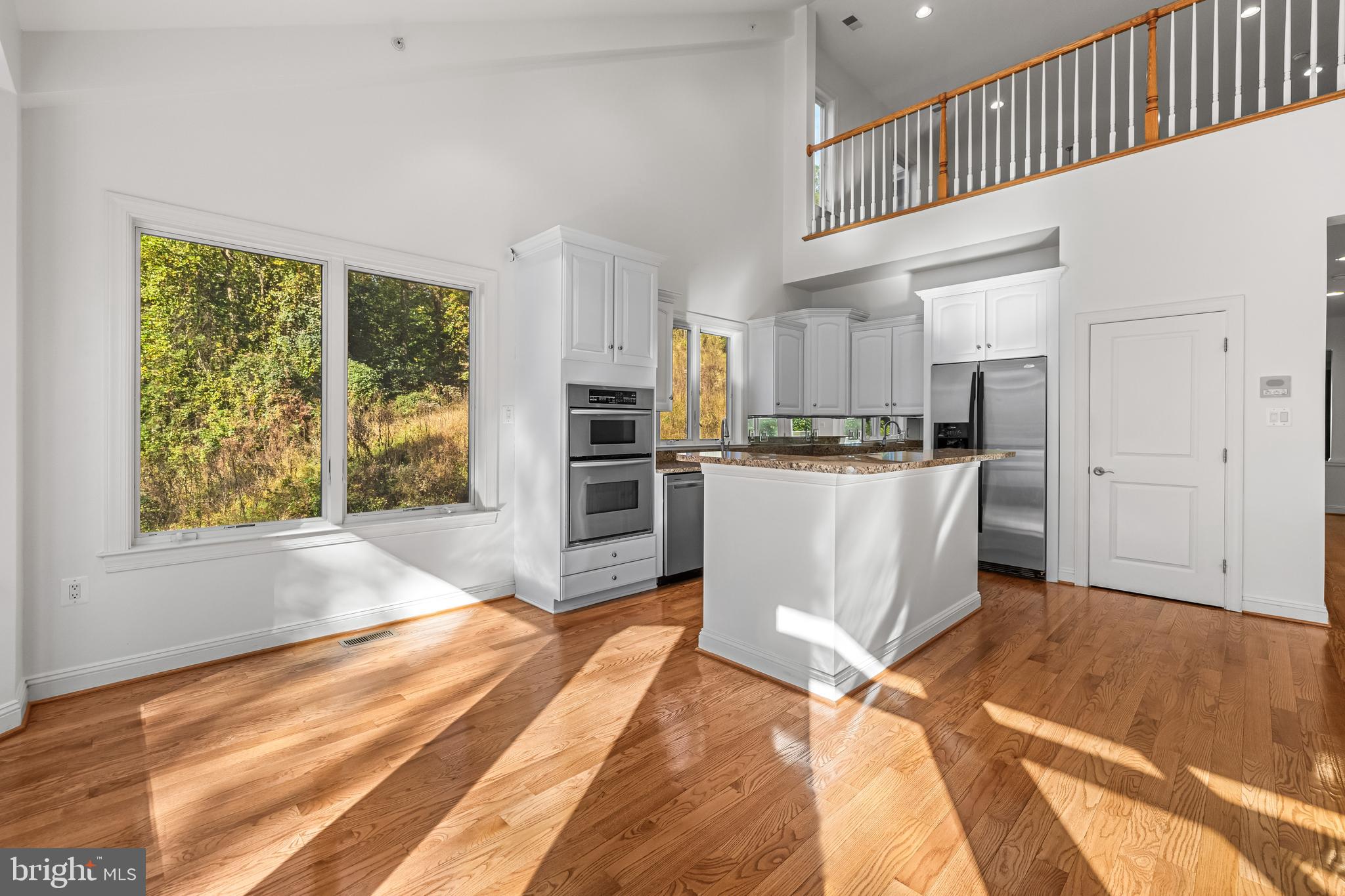 6716 Newstead Lane Baltimore, MD 21209 - Photo 21 of 66 a kitchen with stainless steel appliances kitchen island granite countertop a refrigerator oven a sink dishwasher and white cabinets with wooden floor