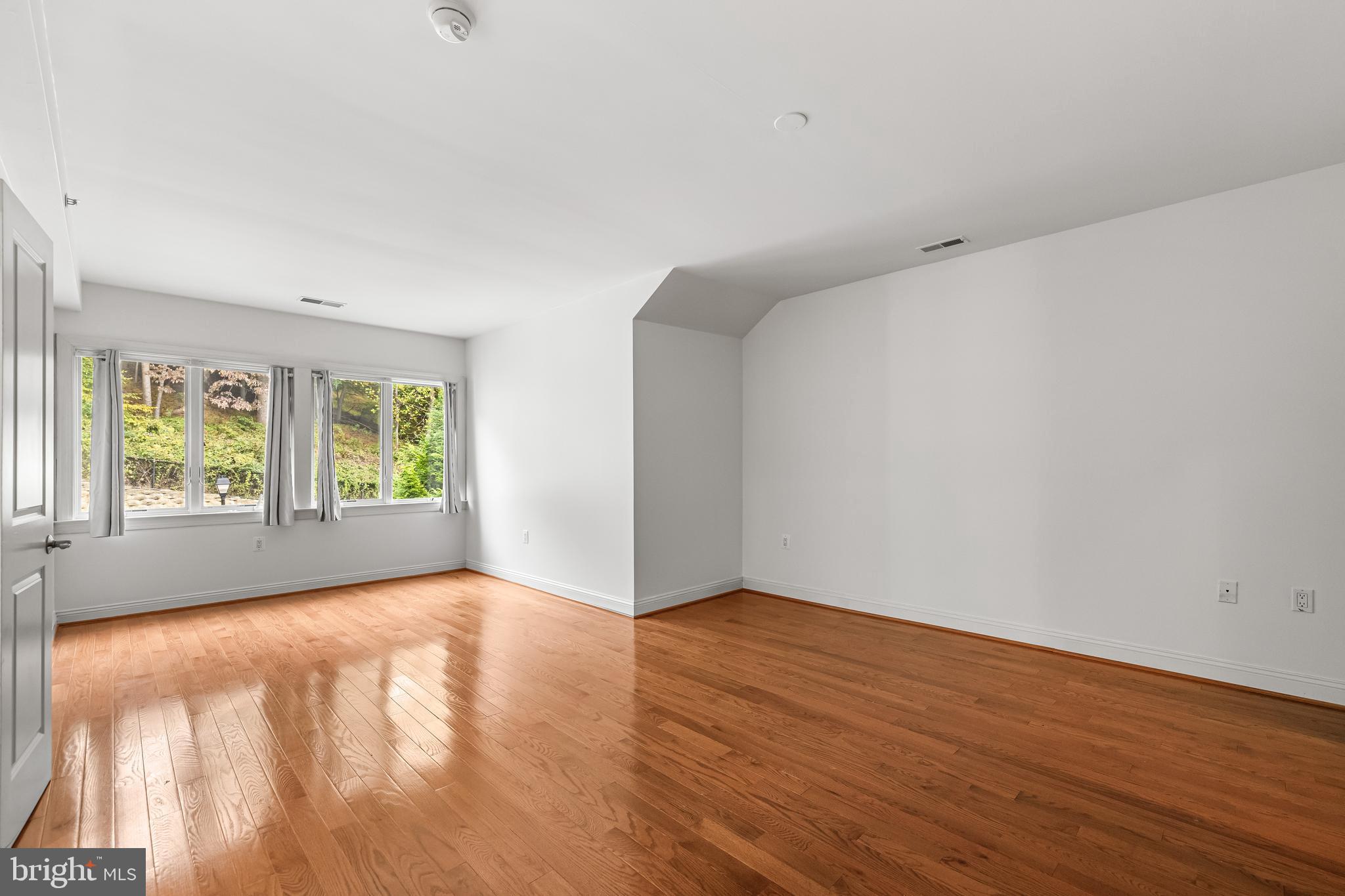 6716 Newstead Lane Baltimore, MD 21209 - Photo 43 of 66 a view of an empty room with wooden floor and a window