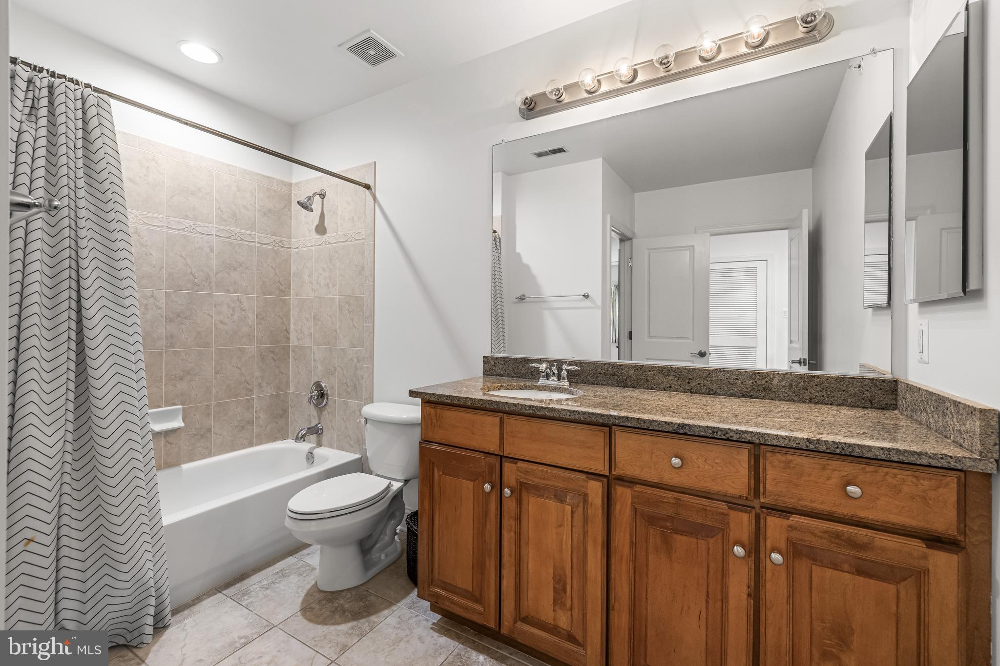 6716 Newstead Lane Baltimore, MD 21209 - Photo 47 of 66 a bathroom with a granite countertop sink a toilet a mirror and shower