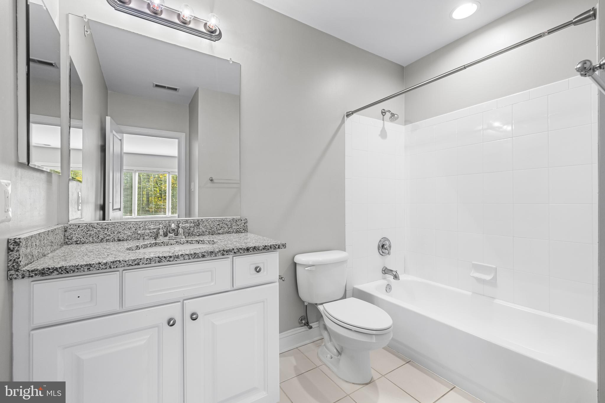 6716 Newstead Lane Baltimore, MD 21209 - Photo 50 of 66 a bathroom with a granite countertop sink toilet a large mirror a bathtub and shower