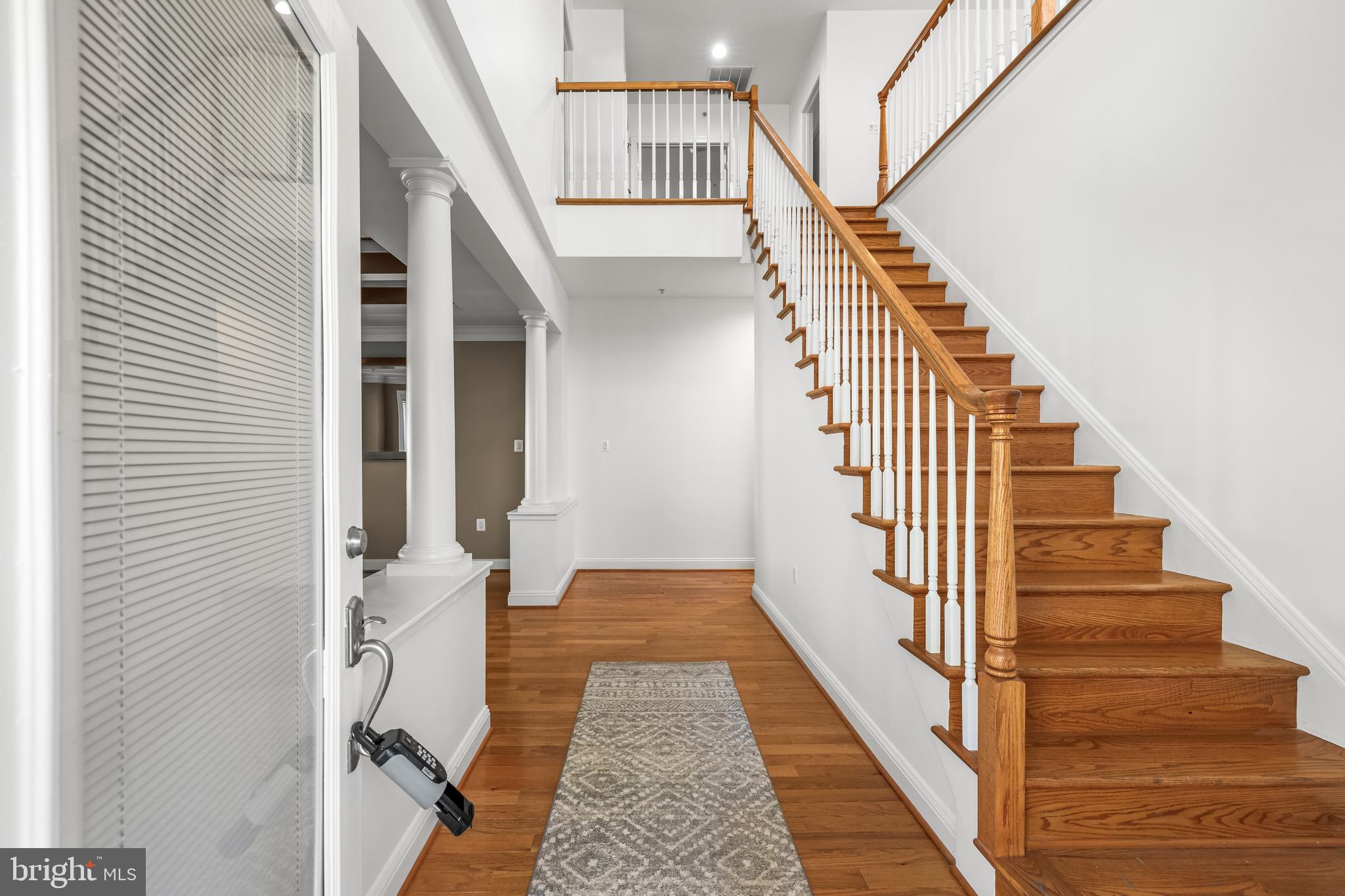 6716 Newstead Lane Baltimore, MD 21209 - Photo 6 of 66 a view of a hallway with wooden floor and staircase