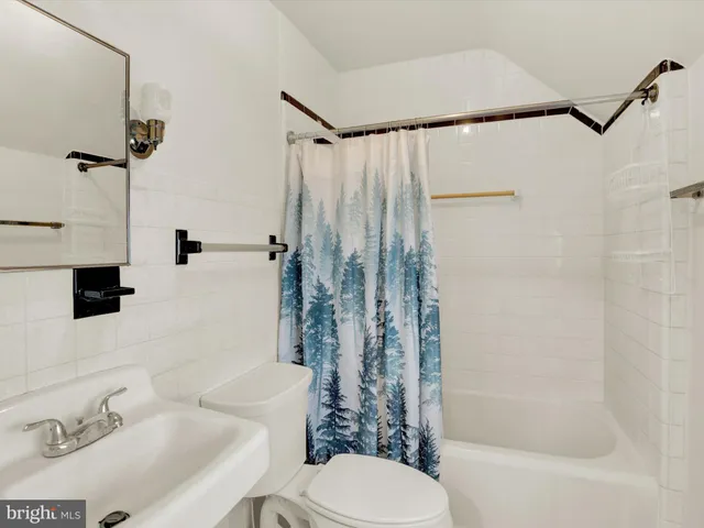 a bathroom with a shower curtain and a toilet