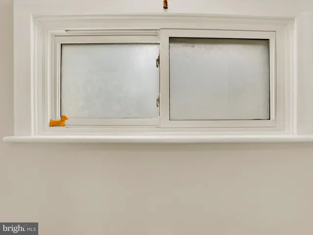 a view of a hallway with wooden floor and a bathroom