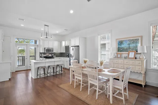 a view of a dining room with furniture a kitchen and chandelier