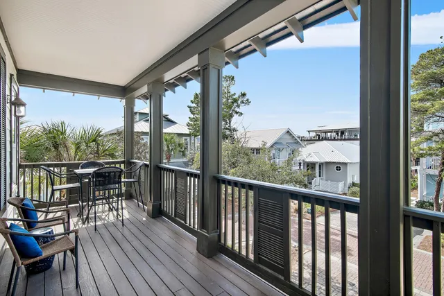 a view of a balcony with chairs and wooden floor