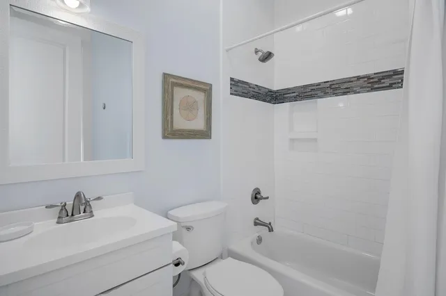 a bathroom with a sink mirror vanity and toilet