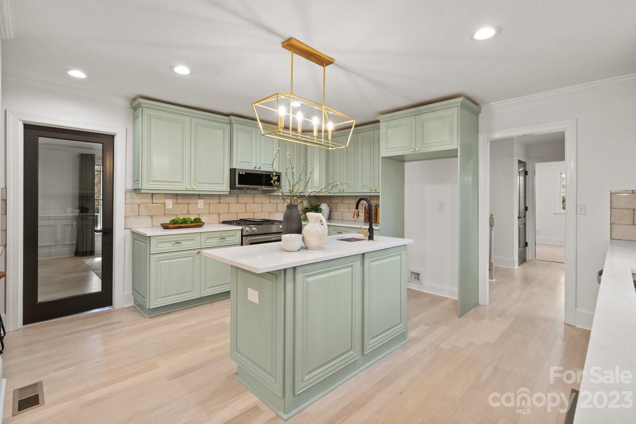 4215 Kuykendall Road Charlotte, NC 28270 - Photo 15 of 43 a kitchen with a sink a center island a stove a refrigerator cabinets and a window