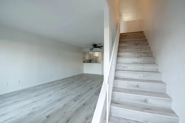 a view of staircase with wooden floor and white walls