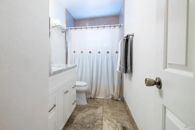 a bathroom with a toilet and a shower
