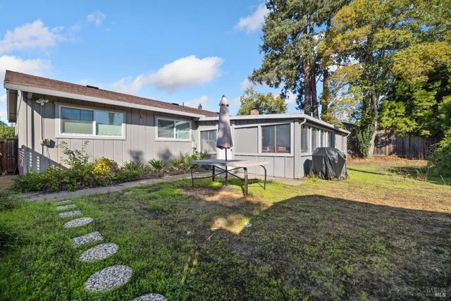 a view of a house with backyard and sitting area