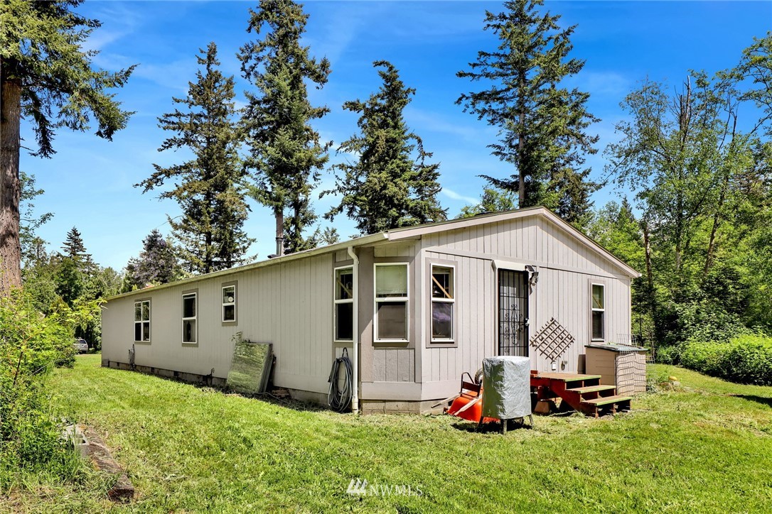 4355 Bridger Road Blaine, WA 98230 - Photo 4 of 12 a view of a white house with a big yard and potted plants large tree