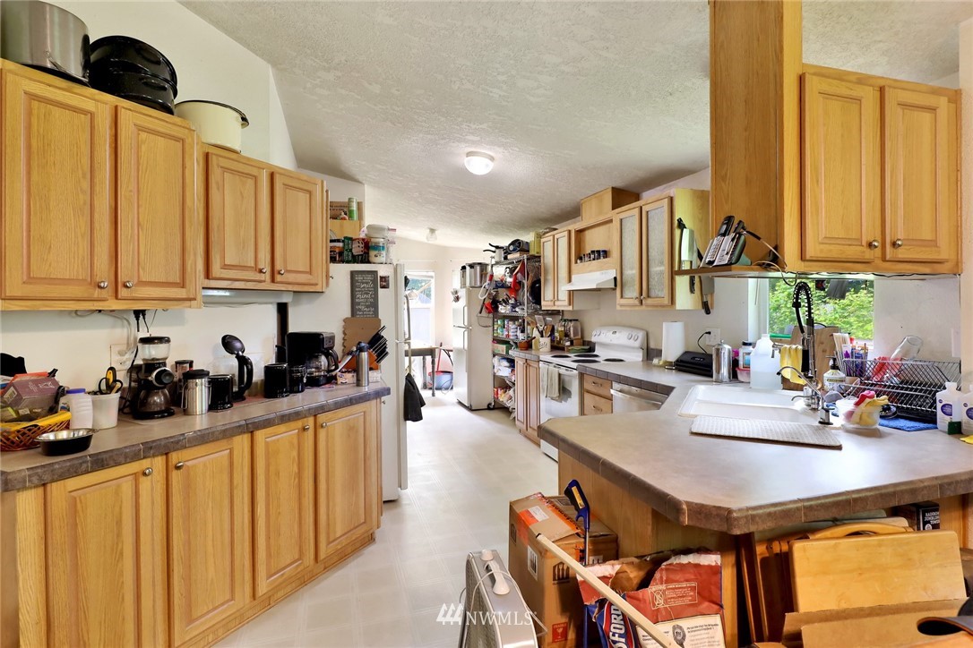 4355 Bridger Road Blaine, WA 98230 - Photo 8 of 12 a kitchen with a refrigerator a stove a sink dishwasher and cabinets with wooden floor
