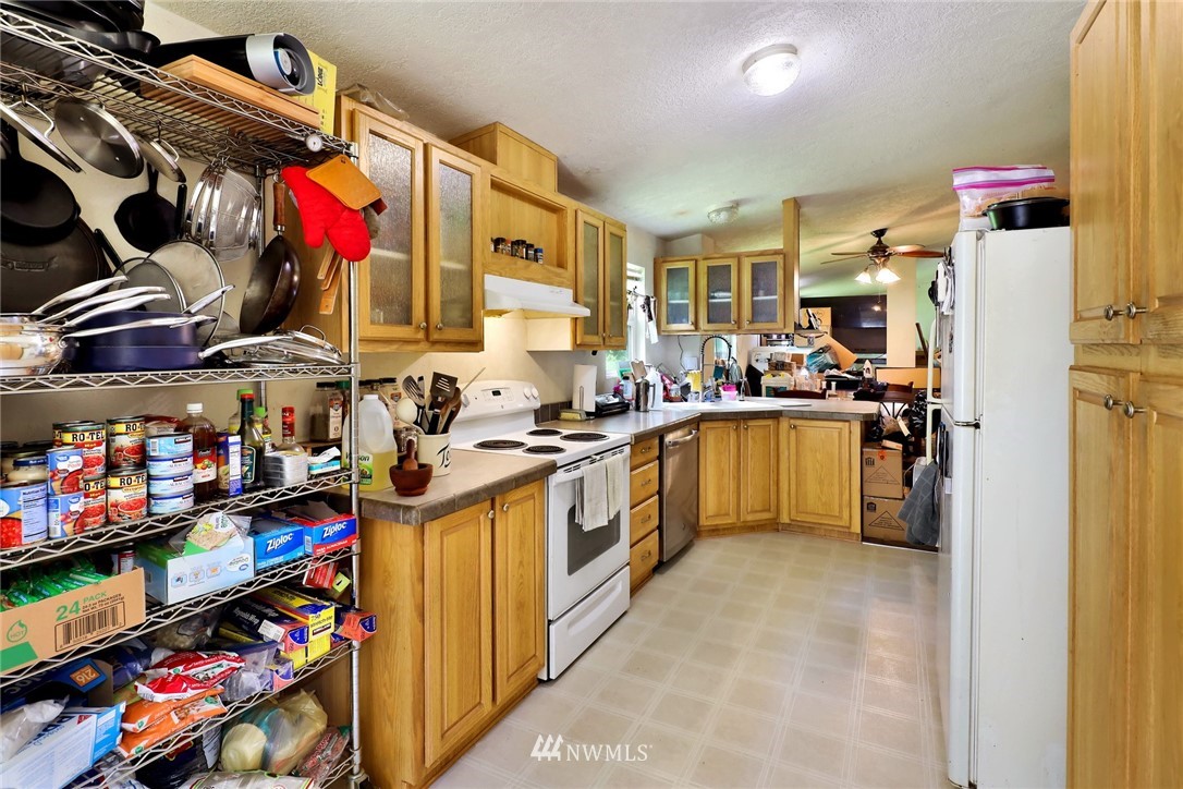 4355 Bridger Road Blaine, WA 98230 - Photo 9 of 12 a kitchen with lots of clutter and stainless steel appliances